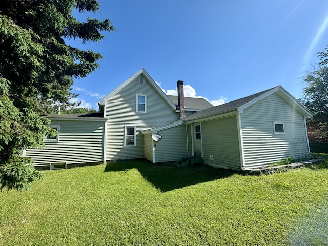 rear view of property featuring a lawn