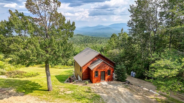 view of front of home featuring a front lawn, an outbuilding, and a mountain view