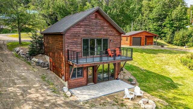 back of house with a lawn and an outdoor structure