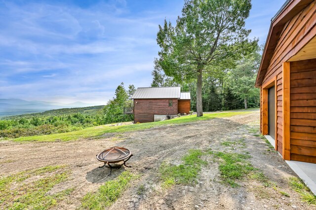 view of yard with an outdoor structure and a fire pit