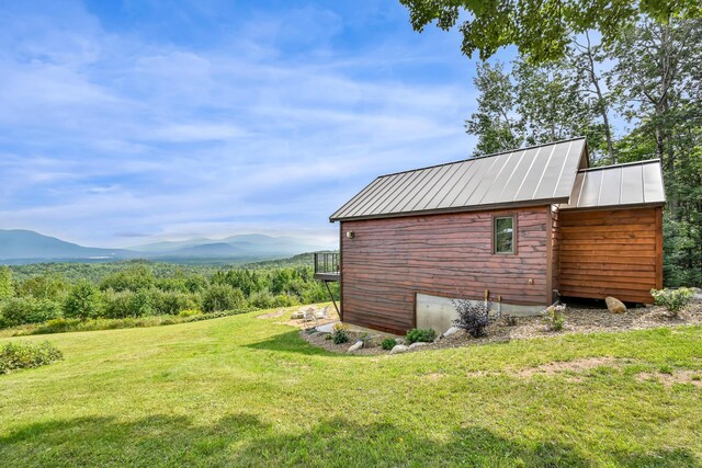 view of outbuilding with a mountain view and a yard