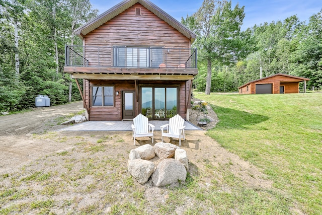 back of house with a deck, french doors, a garage, a yard, and an outbuilding