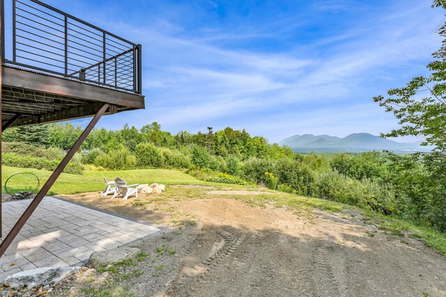 view of yard with a deck with mountain view