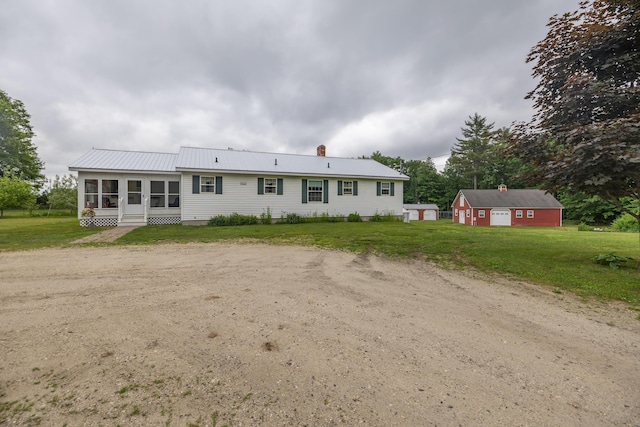 back of property featuring an outdoor structure and a yard