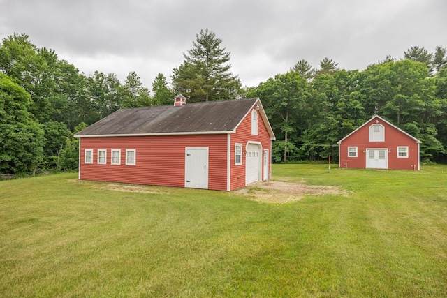 view of outdoor structure featuring a lawn and a garage