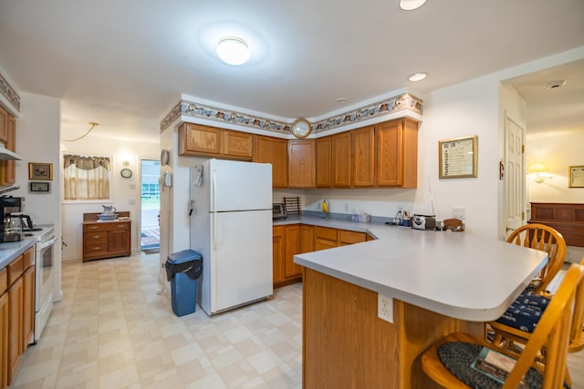 kitchen with white appliances, exhaust hood, an inviting chandelier, a kitchen breakfast bar, and kitchen peninsula