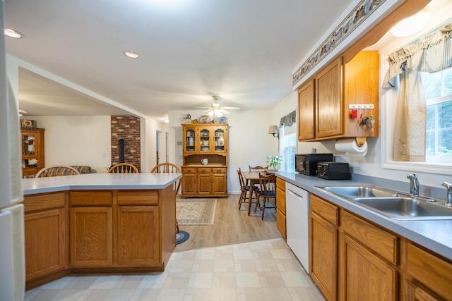 kitchen featuring a wood stove, ceiling fan, sink, and white appliances