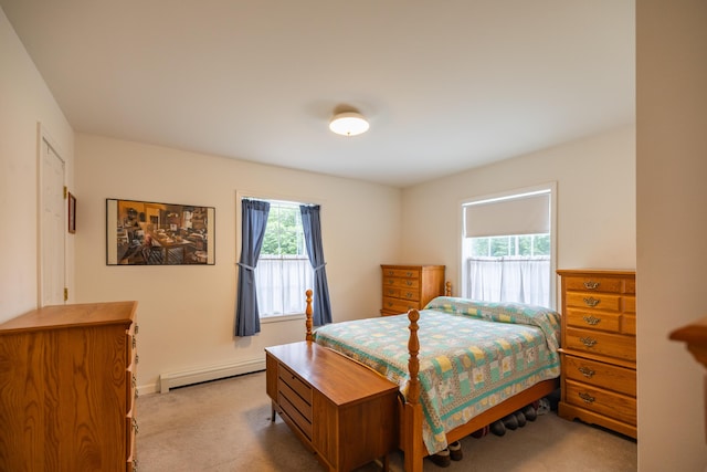 bedroom with light colored carpet and baseboard heating