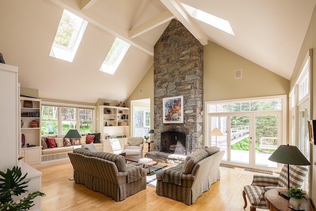 living room featuring a fireplace, light hardwood / wood-style flooring, high vaulted ceiling, and plenty of natural light