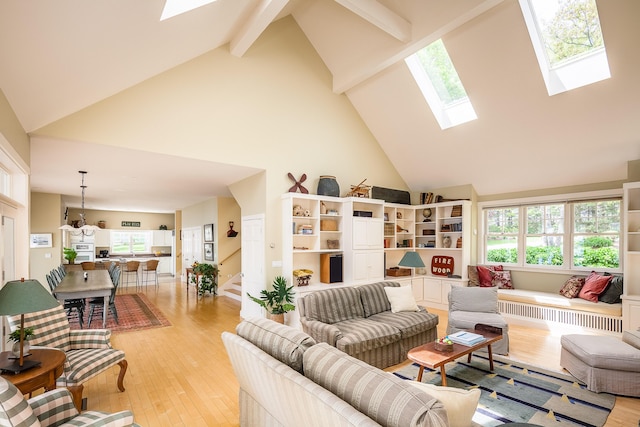 living room with beam ceiling, light wood-type flooring, and high vaulted ceiling