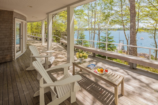 wooden deck with covered porch and a water view