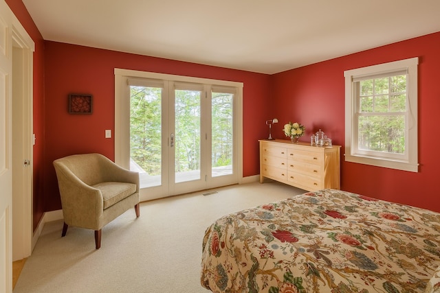 carpeted bedroom featuring access to outside and multiple windows