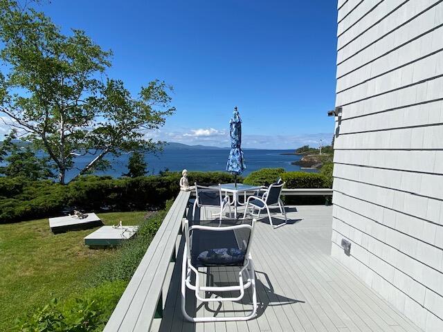 deck featuring a lawn and a water view