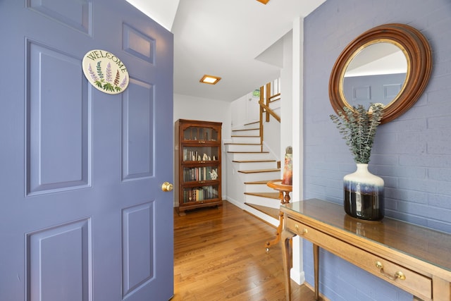 foyer featuring stairway, baseboards, and light wood-style floors