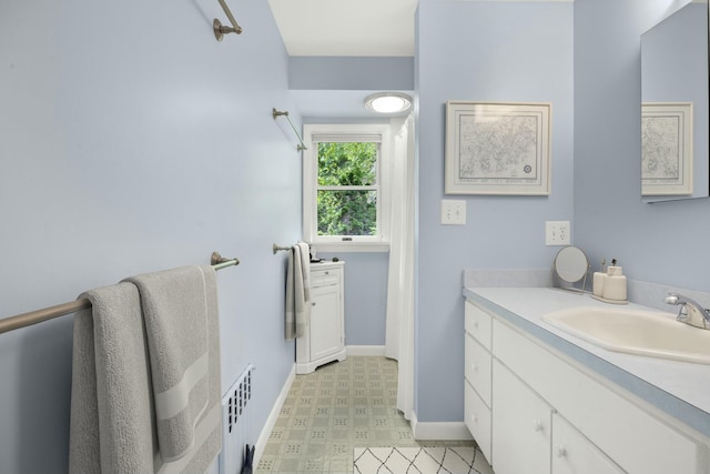 bathroom featuring radiator heating unit, vanity, tile patterned floors, and baseboards