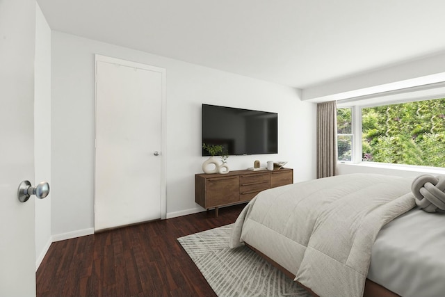 bedroom with baseboards and wood finished floors