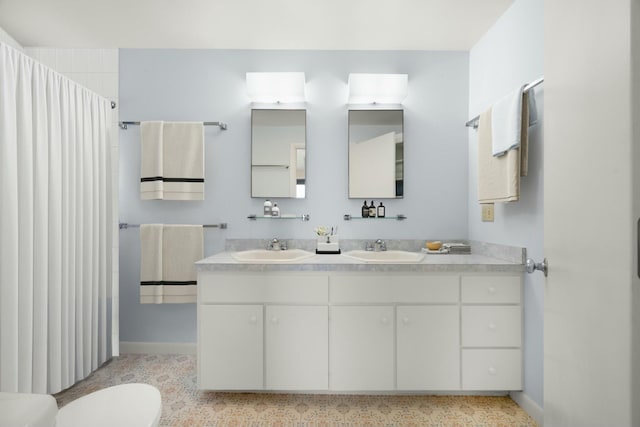 full bathroom featuring baseboards, a sink, and toilet