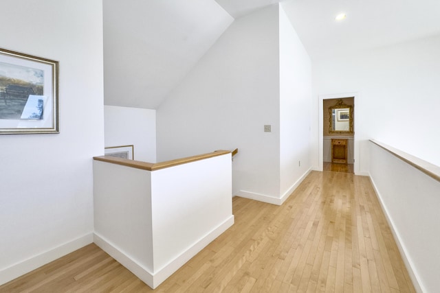 corridor featuring lofted ceiling and light wood-type flooring