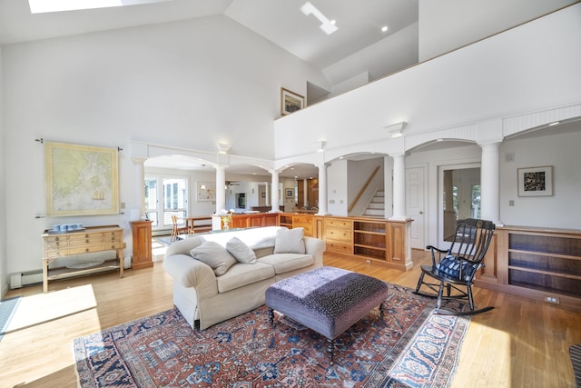 living room with light wood-type flooring and high vaulted ceiling