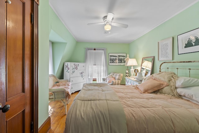 bedroom with ceiling fan, ornamental molding, and light wood-type flooring