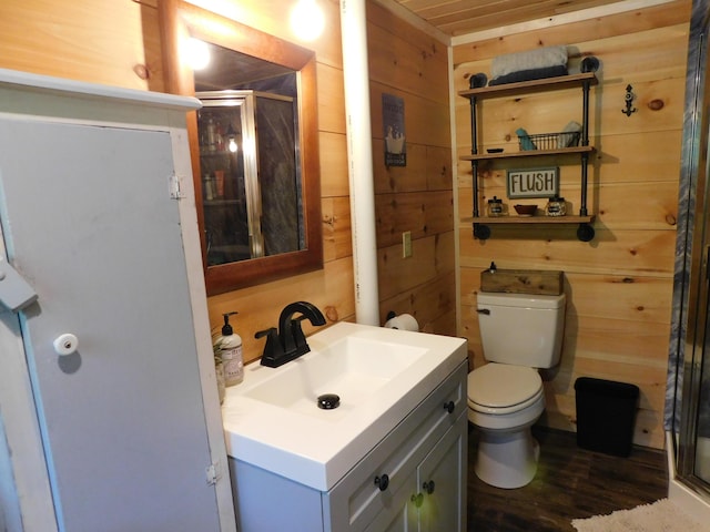 bathroom featuring hardwood / wood-style flooring, toilet, vanity, and wood walls