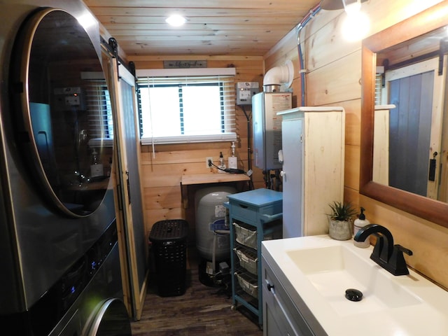 bathroom featuring wooden ceiling, stacked washer and clothes dryer, wood walls, and sink