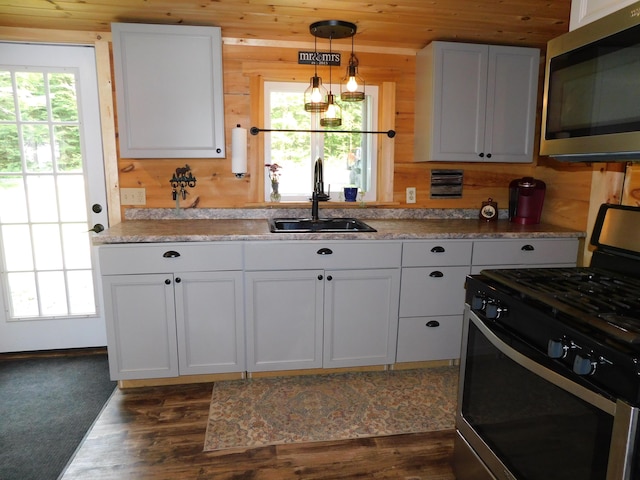 kitchen with a wealth of natural light, white cabinets, appliances with stainless steel finishes, and sink