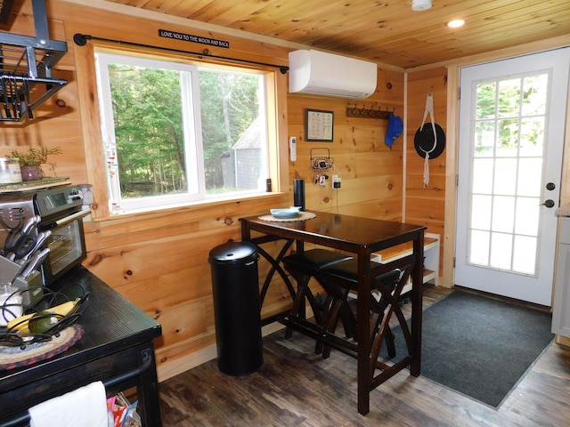 dining space featuring a healthy amount of sunlight, an AC wall unit, and wooden walls