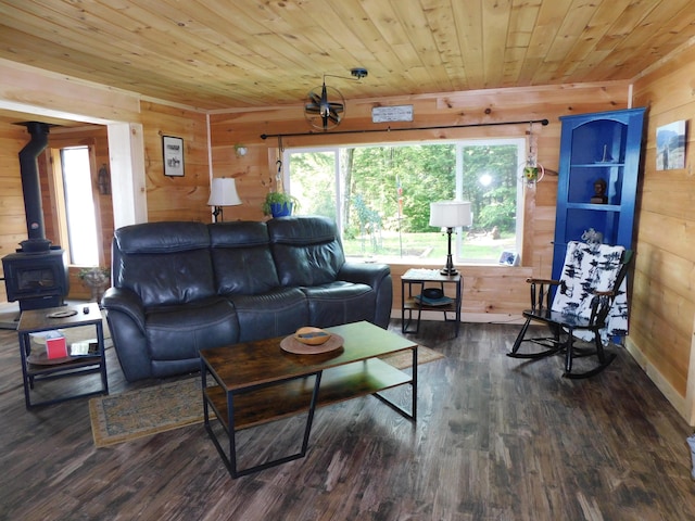 living room featuring wooden ceiling, a wood stove, dark hardwood / wood-style flooring, and wooden walls