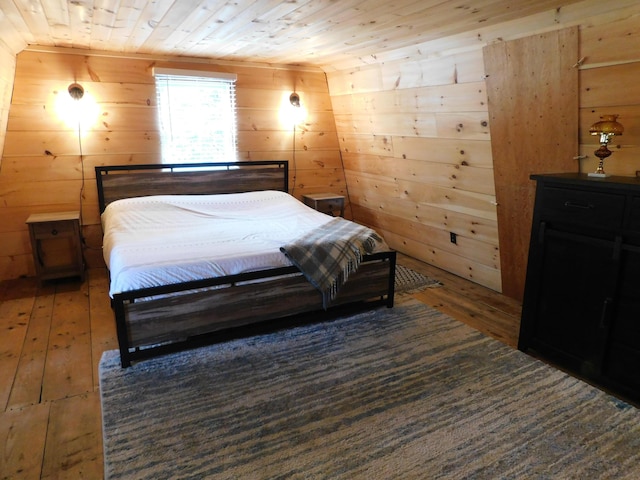 bedroom with wooden ceiling and wooden walls