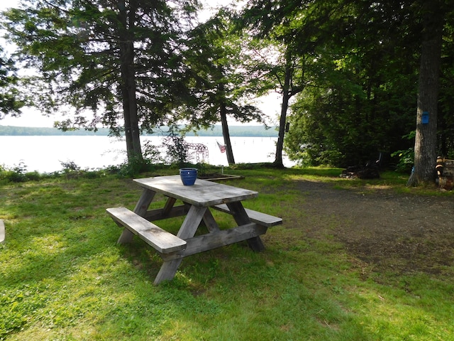 view of community with a lawn and a water view