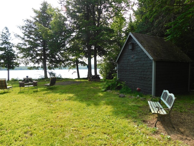 view of yard with a water view and a shed