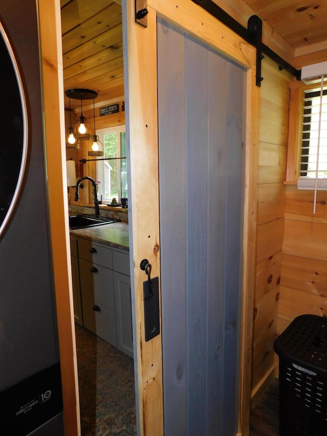 interior space with wood ceiling, sink, and wood walls