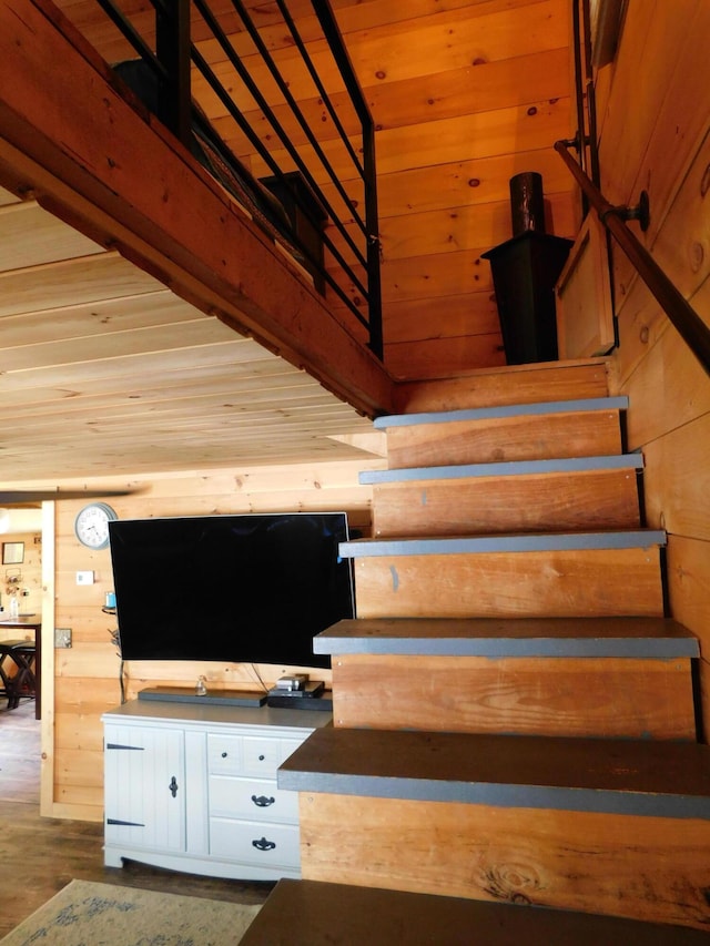 staircase featuring hardwood / wood-style floors and wood walls