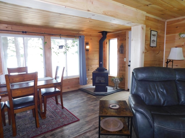 dining area with a wood stove, dark hardwood / wood-style floors, wood walls, and wood ceiling