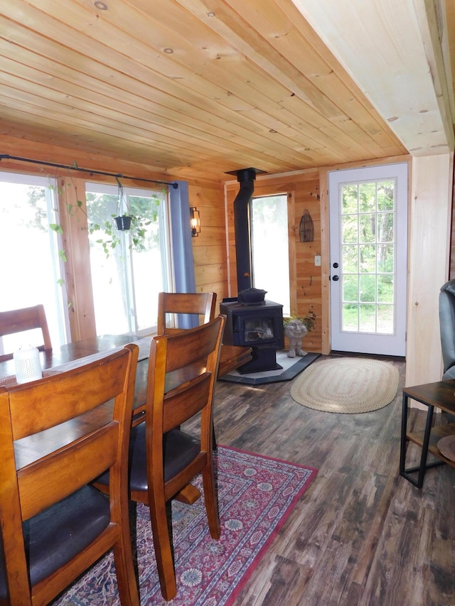 dining area featuring a wood stove, hardwood / wood-style floors, a wealth of natural light, and wood ceiling