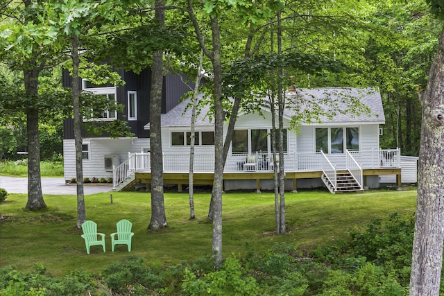 rear view of house with a deck and a lawn