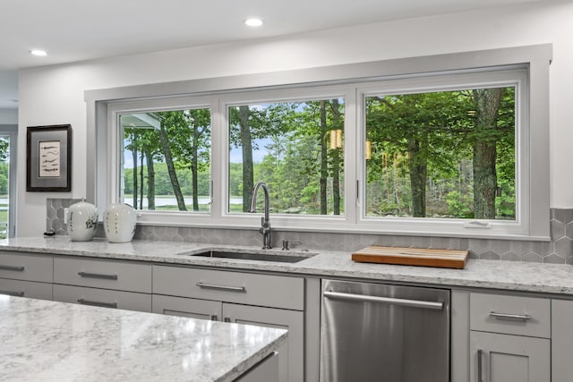 kitchen with light stone counters, sink, a wealth of natural light, and dishwasher