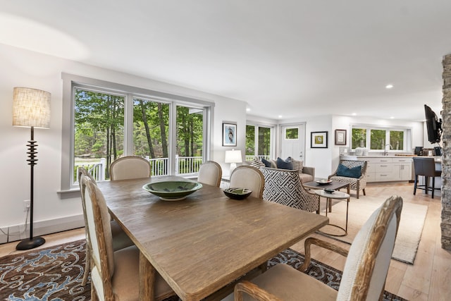 dining space featuring sink, a wealth of natural light, and light hardwood / wood-style floors