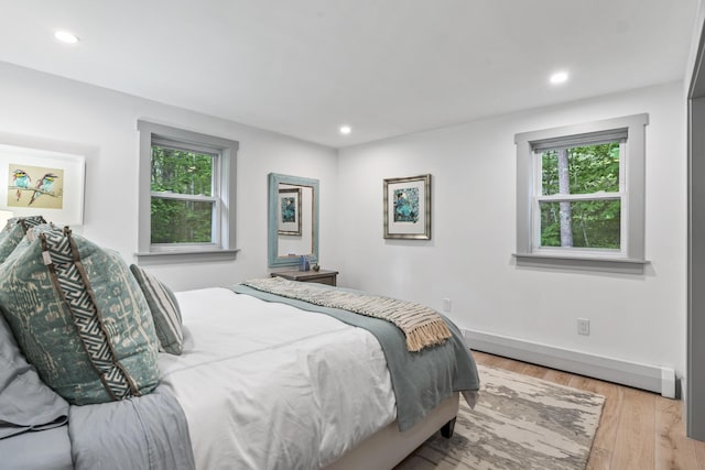 bedroom with multiple windows and light wood-type flooring