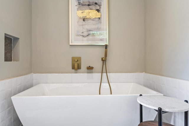 bathroom featuring tile walls and a washtub