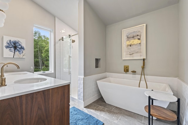 bathroom featuring vanity and independent shower and bath