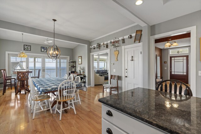 kitchen featuring a wealth of natural light, light hardwood / wood-style floors, hanging light fixtures, and white cabinets