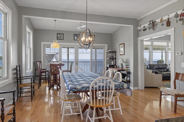 dining room featuring light wood-type flooring, plenty of natural light, and a water view