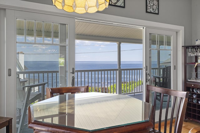 dining area featuring hardwood / wood-style flooring and a water view