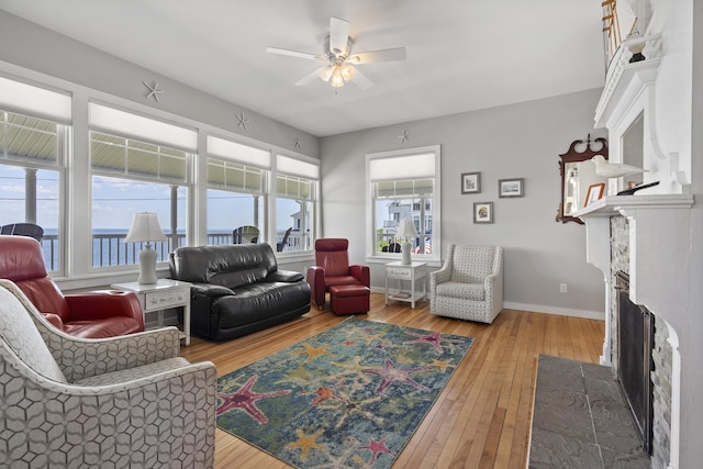 living room featuring a water view, a healthy amount of sunlight, and hardwood / wood-style floors