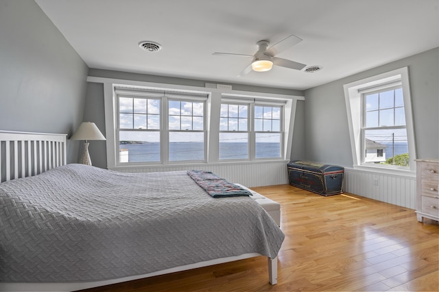 bedroom with a water view, ceiling fan, and light hardwood / wood-style floors