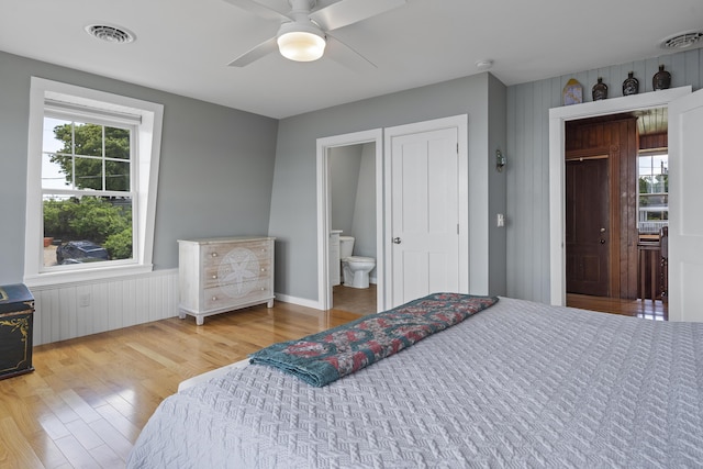 bedroom with ceiling fan, ensuite bath, and light wood-type flooring