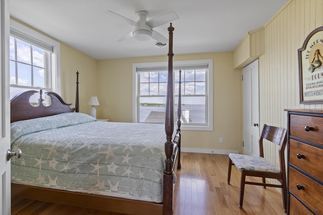 bedroom featuring ceiling fan, multiple windows, and light wood-type flooring