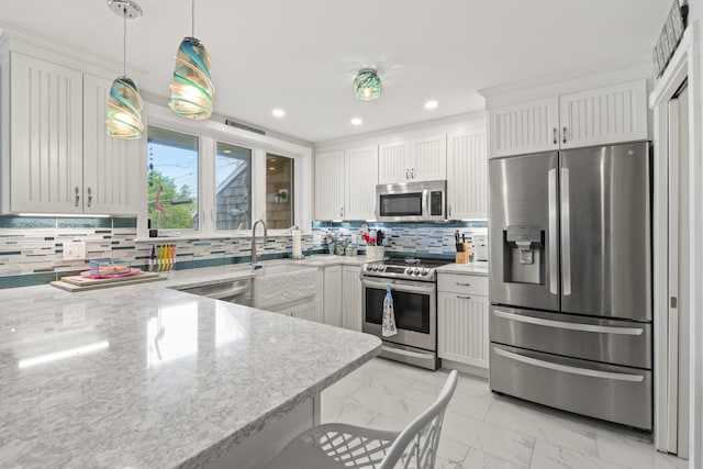 kitchen featuring white cabinetry, appliances with stainless steel finishes, light stone counters, and pendant lighting